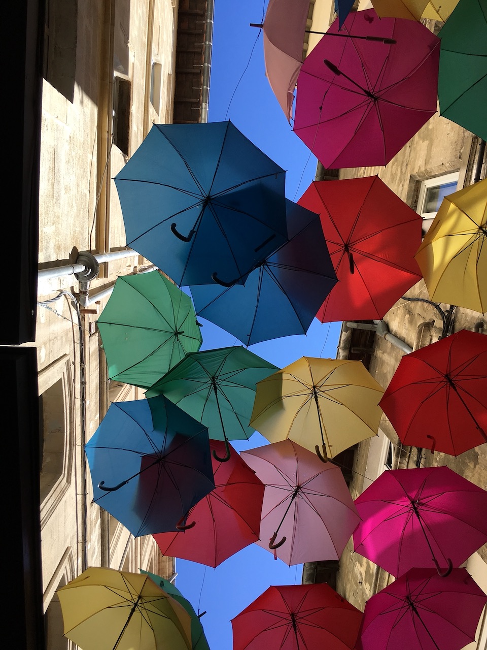 Umbrella shadows on Avignon cobblestones